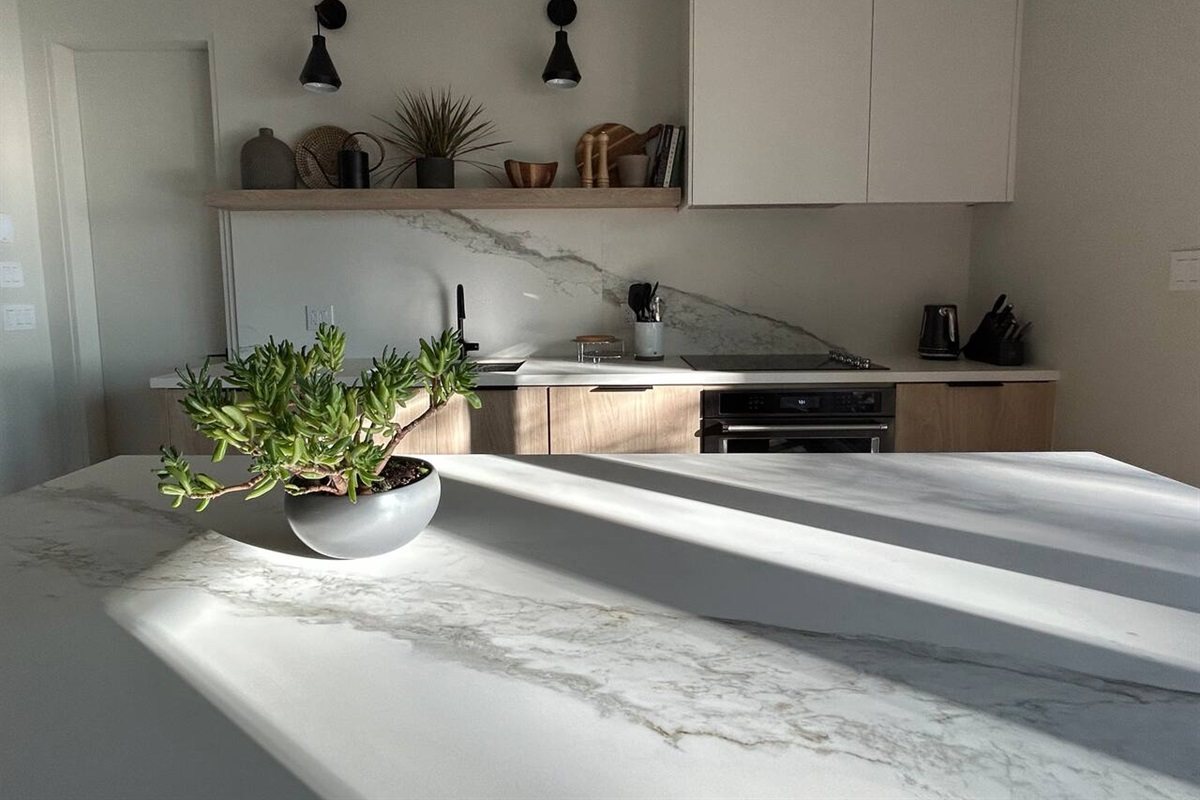 La cuisine de chef : l’îlot dans la lumière du matin, la cuisinière derrière