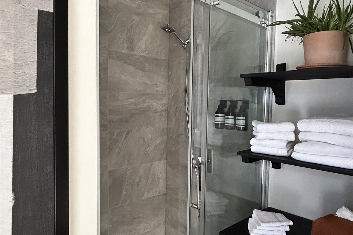 La salle de bain de la suite à lits superposés, la douche et les serviettes pliées